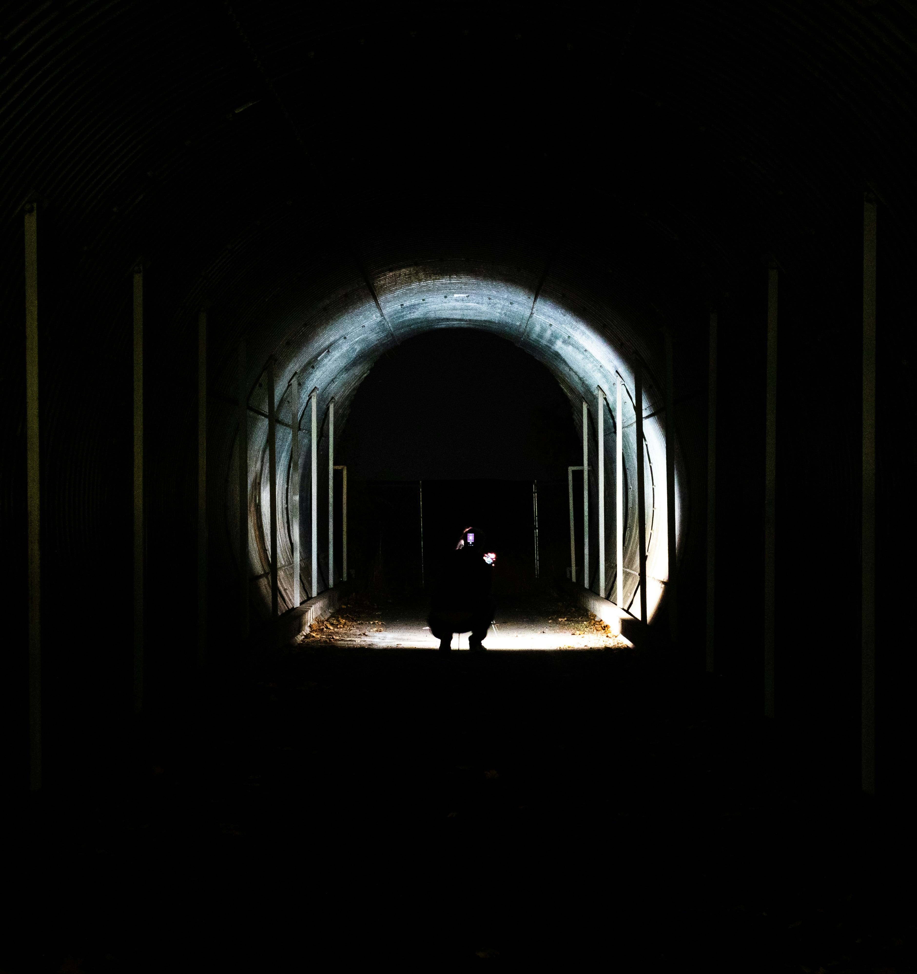 person sitting inside tunnel